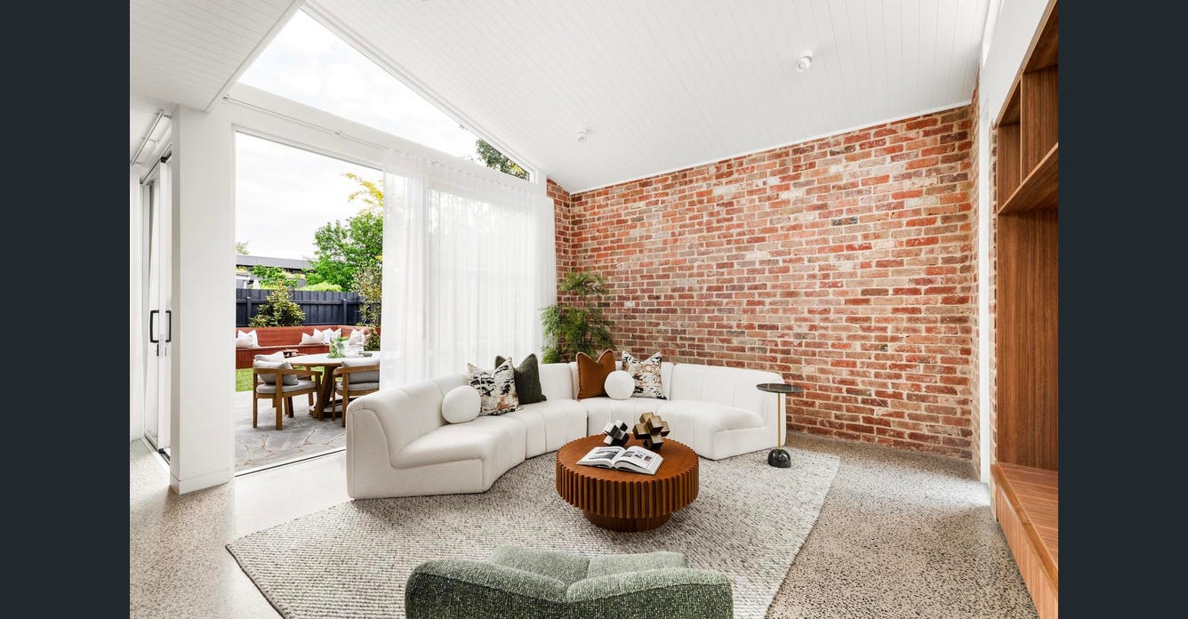 Union Street Brunswick living room opening to rear courtyard with brick feature wall