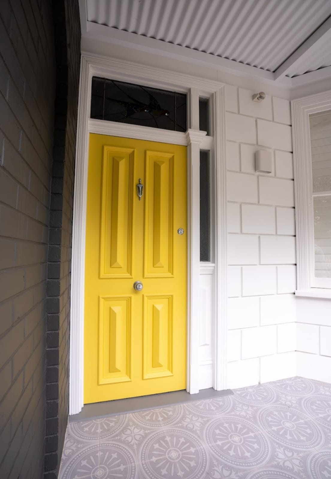 Classic home entrance with a vibrant yellow door renovated by JSG Construct.